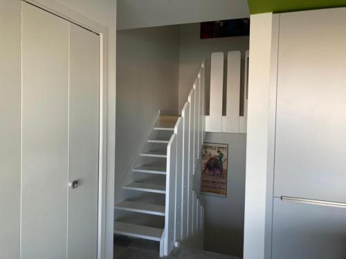 - un escalier dans une chambre aux murs blancs dans l'établissement Marina, au Grau-du-Roi