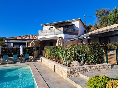 une maison avec une piscine devant une maison dans l'établissement côte et mer - appartement haut standing dans villa avec piscine et vue mer, à Taglio-Isolaccio