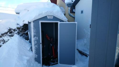 a out house with snow on top of it at Les pagotins de Garance, Chalet chaleureux Chat Gris, cosy et classé 3 étoiles in Métabief