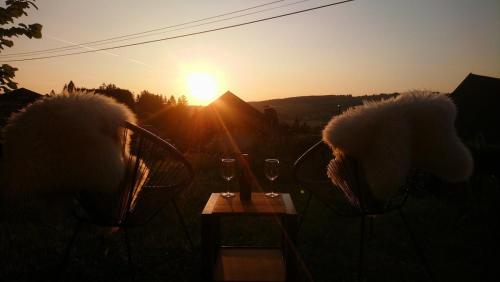 two people sitting in chairs watching the sunset at Les pagotins de Garance, Chalet chaleureux Chat Gris, cosy et classé 3 étoiles in Métabief