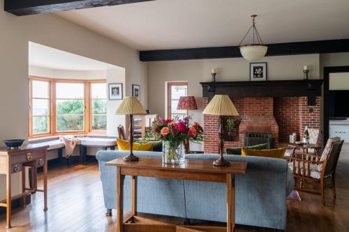 a living room with a couch and a table with flowers on it at Amber Tide in Thurlestone