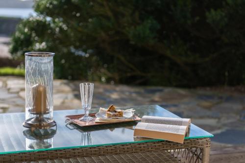 a table with a glass vase and a plate of food at Amber Tide in Thurlestone