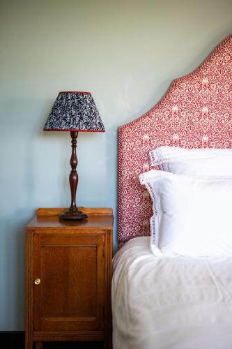 a lamp on a night stand next to a bed at Amber Tide in Thurlestone