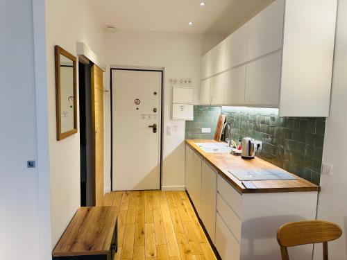 une cuisine avec des armoires blanches et un comptoir en bois dans l'établissement Studio Tour Eiffel Quai de Seine Paris, à Paris