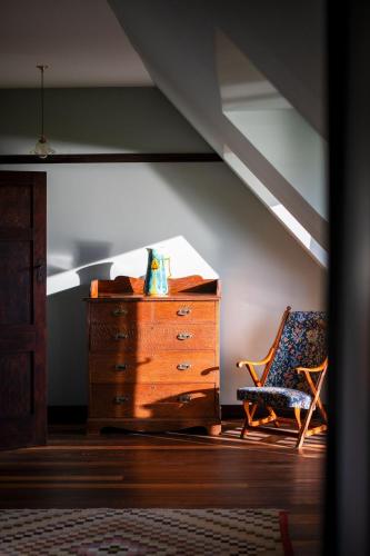 a dresser and a chair in a room with an attic at Amber Tide in Thurlestone