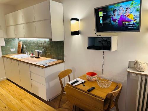 Il comprend une cuisine avec une table et une télévision murale. dans l'établissement Studio Tour Eiffel Quai de Seine Paris, à Paris