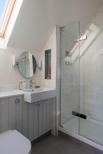 a bathroom with a sink and a shower at Amber Tide in Thurlestone