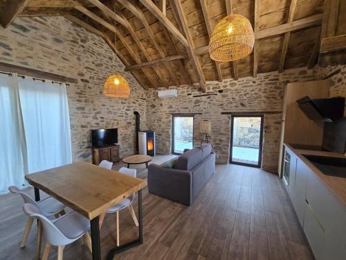 a living room with a table and a couch at Bergerie en plein nature - SPA PRIVATIF in Le Lonzac