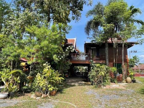 a house with a wrap around porch and trees at Niyang Siam House in Nai Yang Beach