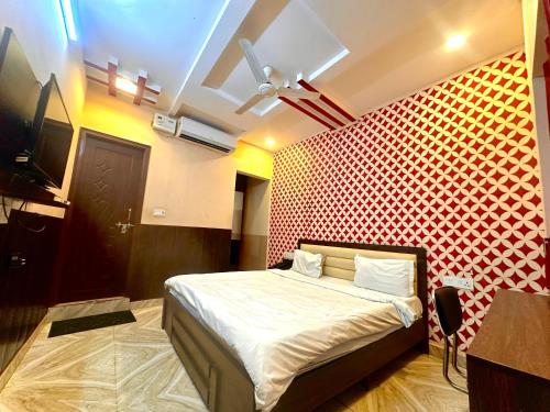 a bedroom with a bed and a red wall at Hotel Airport Gateway in Lucknow