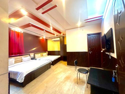 a hotel room with two beds and a tv at Hotel Airport Gateway in Lucknow
