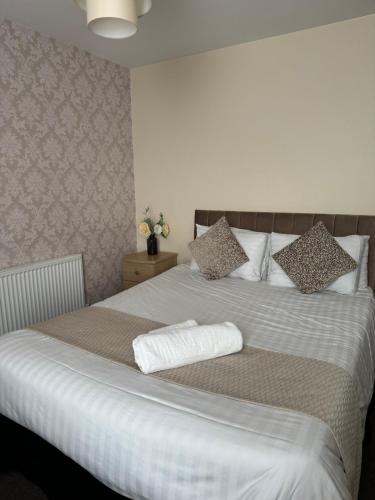 a bedroom with a large white bed with pillows at The Station Hotel in Worksop