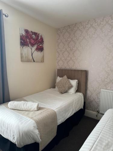 a bedroom with two beds and a painting on the wall at The Station Hotel in Worksop