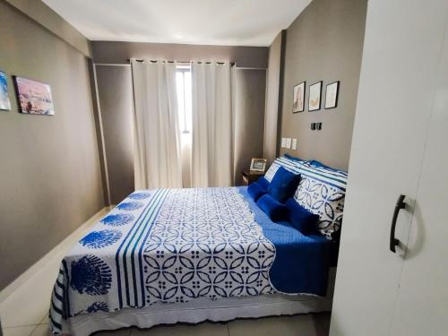 - une chambre avec un lit bleu et blanc et une fenêtre dans l'établissement Lindo apartamento, ao lado do Shopping Partage Nova Betânia Ed WHB, à Mossoró