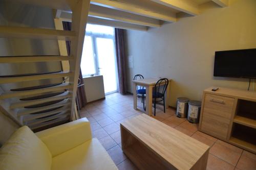 a living room with a couch and a television at Condo Gardens Leuven in Leuven