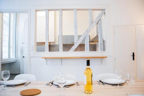 une bouteille de vin posée sur une table avec des verres dans l'établissement Wonderhost, volumes incroyables & chambre Royale, à Pau