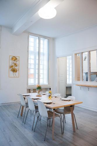 une salle à manger avec une table et des chaises blanches dans l'établissement Wonderhost, volumes incroyables & chambre Royale, à Pau