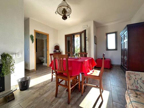 a dining room with a red table and chairs at Agriturismo il Pianetto in Principina Terra
