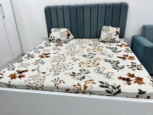 Una cama con una manta y almohadas encima en Royal Orbit studio, en Noida