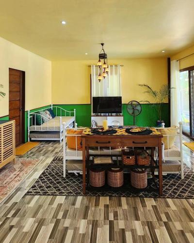 Una sala de estar con una mesa y una cama. en casaarseniovilla, en Taytayan