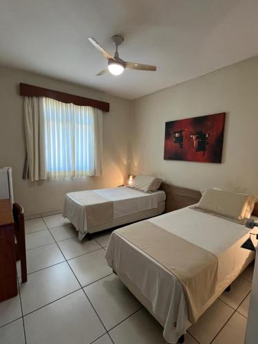a bedroom with two beds and a ceiling fan at Hotel Muller in Mariana