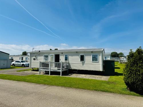 a white mobile home with a porch and a driveway at Summer Dreams Holiday Home Skegness in Skegness