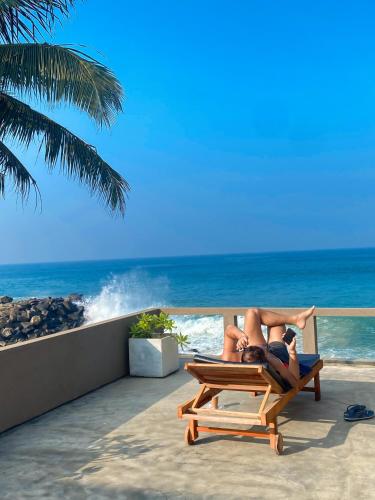 two people laying in a chair on the beach at Villa Sea Queen in Ambalangoda
