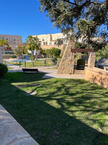 a park with a bench in the grass at Holidays Urban Home in Caserío Almayate Bajo