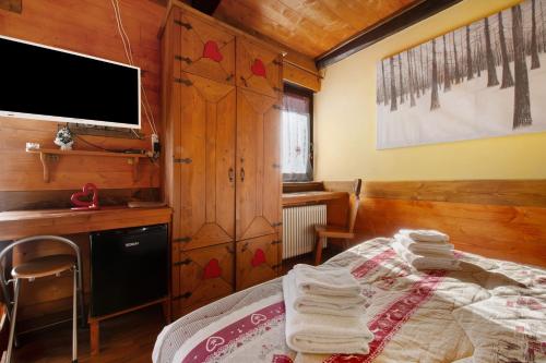a bedroom with a bed and a desk and a tv at Arthemisia - Rhêmes-Notre-Dame in Rhêmes-Notre-Dame