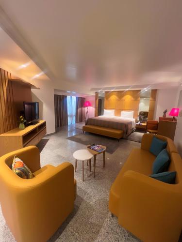 ラゴスにあるEko Hotel Main Buildingのベッドとリビングルームがあるホテルの部屋