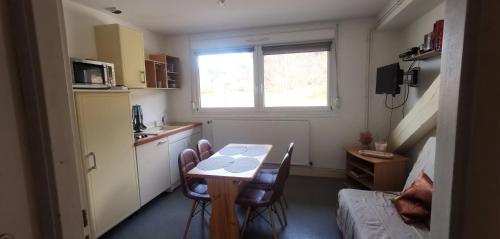 a kitchen with a table and chairs in a room at Evasion Gérardmer in Gérardmer