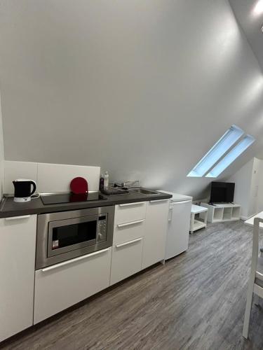 a kitchen with white cabinets and a stove at Ferienwohnung am Uniklinik Lübeck in Lübeck