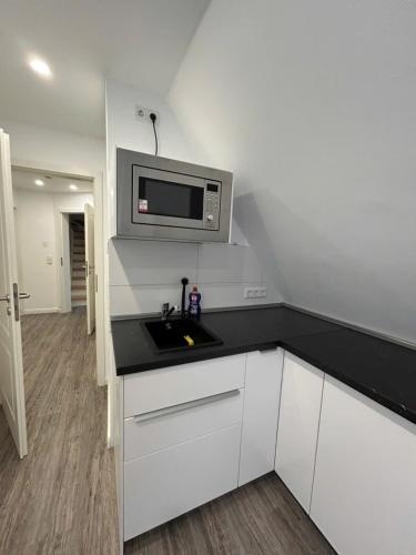 a kitchen with a sink and a microwave at Ferienwohnung am Uniklinik Lübeck in Lübeck