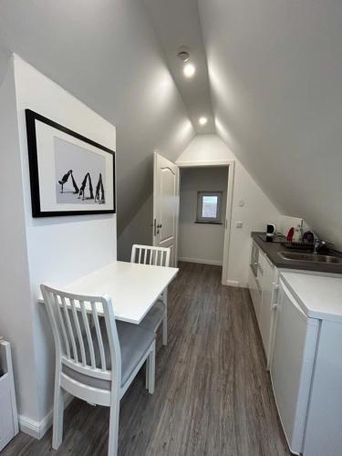 a kitchen with a white table and chairs in a room at Ferienwohnung am Uniklinik Lübeck in Lübeck