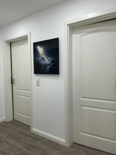 a room with two doors and a painting on the wall at Ferienwohnung am Uniklinik Lübeck in Lübeck