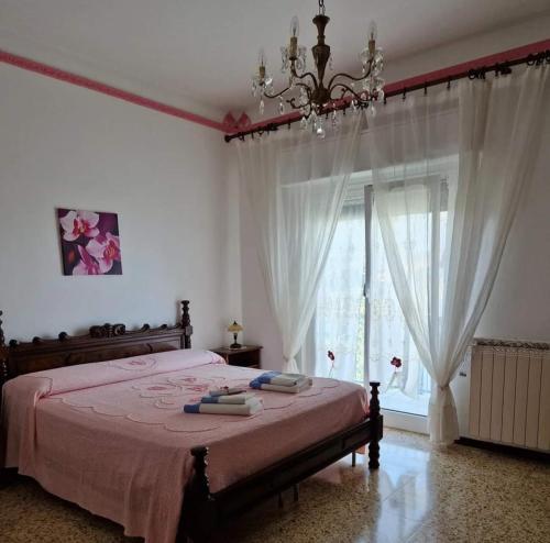 sypialnia z łóżkiem z żyrandolem i oknem w obiekcie B&B Mare e Monti w mieście La Spezia