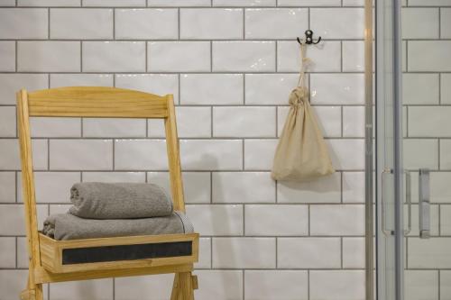 a wooden chair in a bathroom with white tiled walls at Zielony Wojszyn in Wojszyn