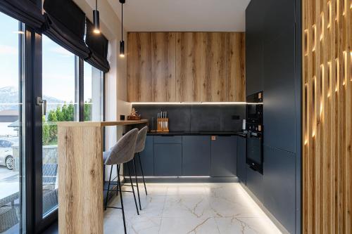 a kitchen with black walls and a bar with stools at Chalet 348 in Palyanytsya