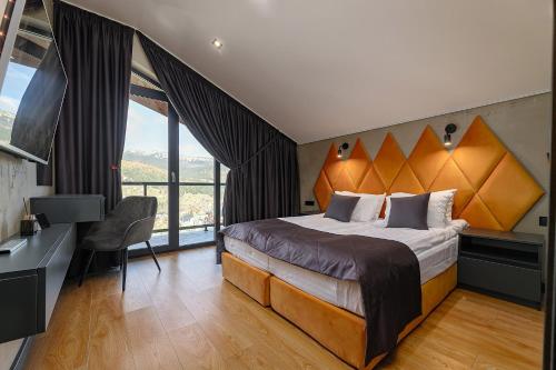 a bedroom with a large bed with a large window at Chalet 348 in Palyanytsya
