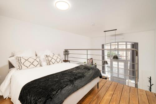 a bedroom with a bed with a black blanket at L'Eden d'Elyse - Duplex premium- parking gratuit in Nancy