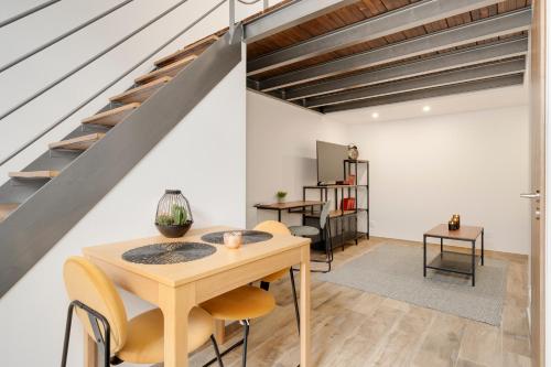 une salle à manger avec une table et un escalier dans l'établissement L'Eden d'Elyse - Duplex premium- parking gratuit, à Nancy