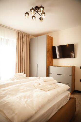 a bedroom with a white bed with a flat screen tv at Chalet 348 in Palyanytsya