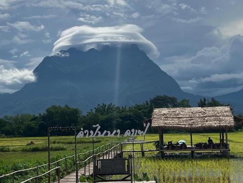 a cloud over a mountain with a hut in a field at Khampanna Cafe' resort & Nature in Ban Sop Nong