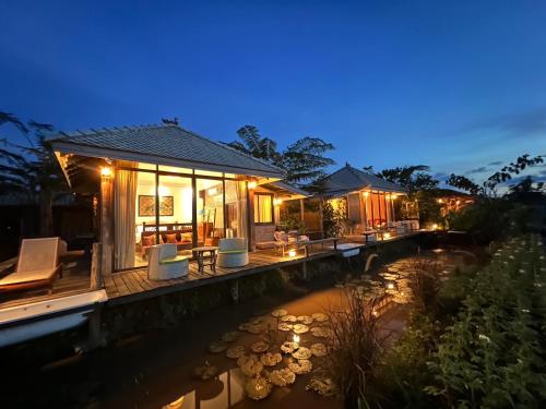 a house with a river in front of it at night at Khampanna Cafe' resort & Nature in Ban Sop Nong
