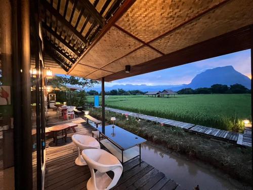 a patio with a table and chairs and a view of a field at Khampanna Cafe' resort & Nature in Ban Sop Nong