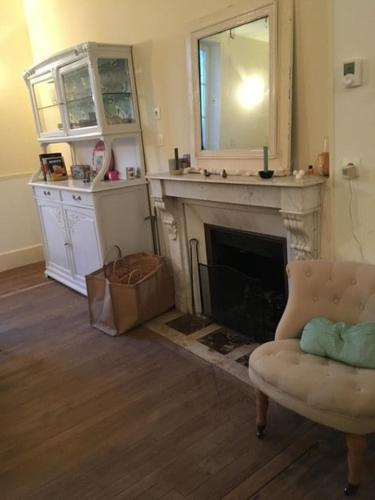 - un salon avec une cheminée et une chaise dans l'établissement Maison de charme au cœur d'Ervy-le-Châtel, à Ervy-le-Châtel