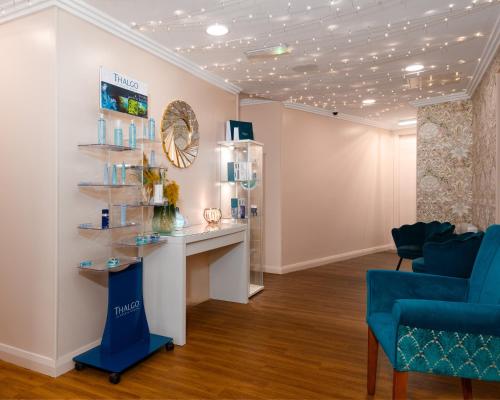 a room with a blue chair and a shelf at Scotland's Spa Hotel in Pitlochry