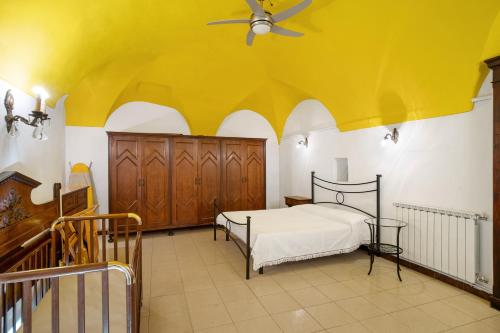 Casa bici sole e mare في سان لورينزو الماري: غرفة نوم بسرير وسقف اصفر