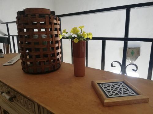 a vase with flowers on a table with a window at Casa Diafa in Órgiva