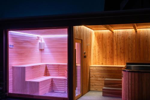 a pink sauna with a tub in a room at Willa Podhalanka Jacuzzi & sauna - drewniany dom dla 20 osób in Biały Dunajec